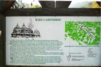 Leśna tablica z mapką i historyczną notką o wsi Caryńskie.